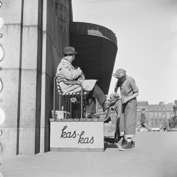 1952 . Kengänkiillottajapoika Rautatieaseman edustalla Helsingin olympialaisten aikana. Kas-kas kenkävoiteen mainosteksti.